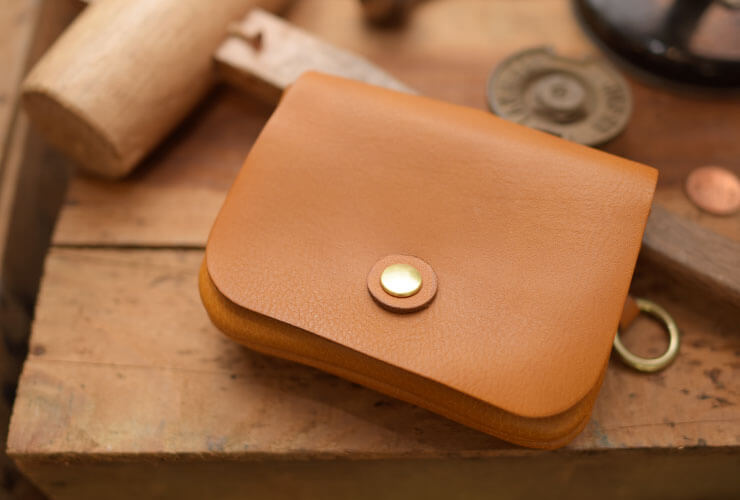 丸いフォルムと遊び心溢れるデザインが愛らしい二つ折り財布 / 革鞄の